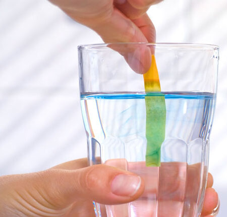 pH litmus test in glass of water