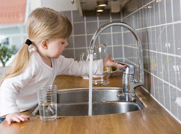 Child using sink faucet